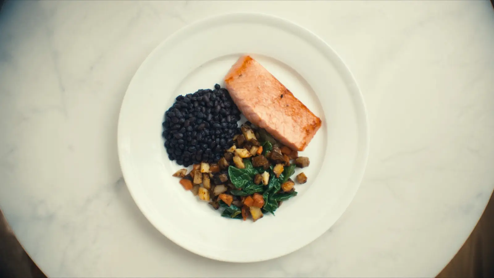 Realistic photographic still life of a balanced PCOS-friendly meal on a clean white plate: grilled salmon, lentils, roasted c